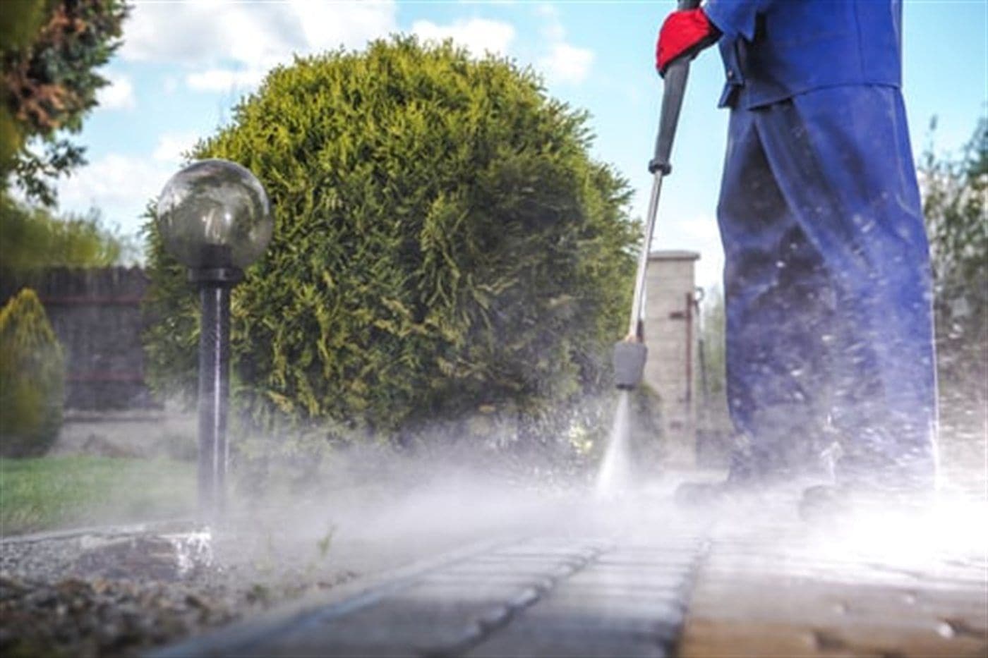 Pereiras Cleaning Service technician pressure washing a Long Island driveway